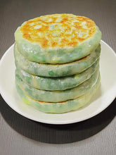 Stack of green and yellow pancakes on a white plate
