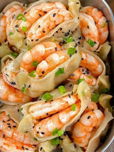 Shrimp and pasta dish with green onions and black sesame seeds in a bowl
