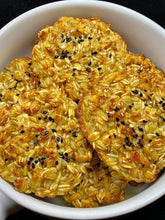 Crispy rice cakes with sesame seeds in a white bowl