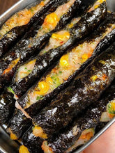 Rolled sushi with vegetables and shrimp in a metal container