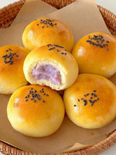 Assorted bread rolls with sesame seeds on a woven basket