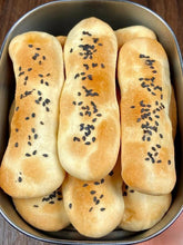 Bread rolls with sesame seeds in a metal container