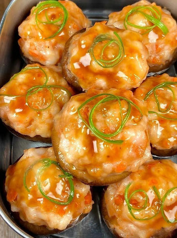 Baked stuffed mushrooms with a sauce and green onions on top
