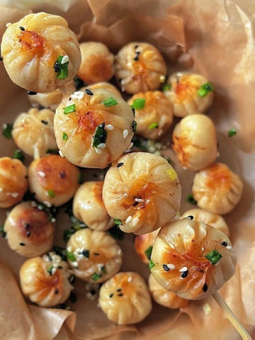 Skewers of small, round, breaded and fried snacks with a golden-brown crust on a light brown paper background.