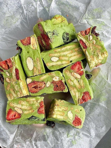Green nougat with strawberries and nuts on a crumpled white paper background