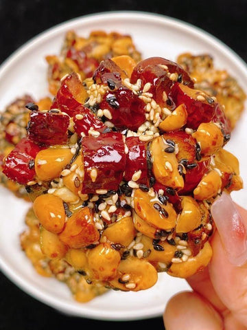 Close-up of a dish with roasted chestnuts and red dates on a white plate.
