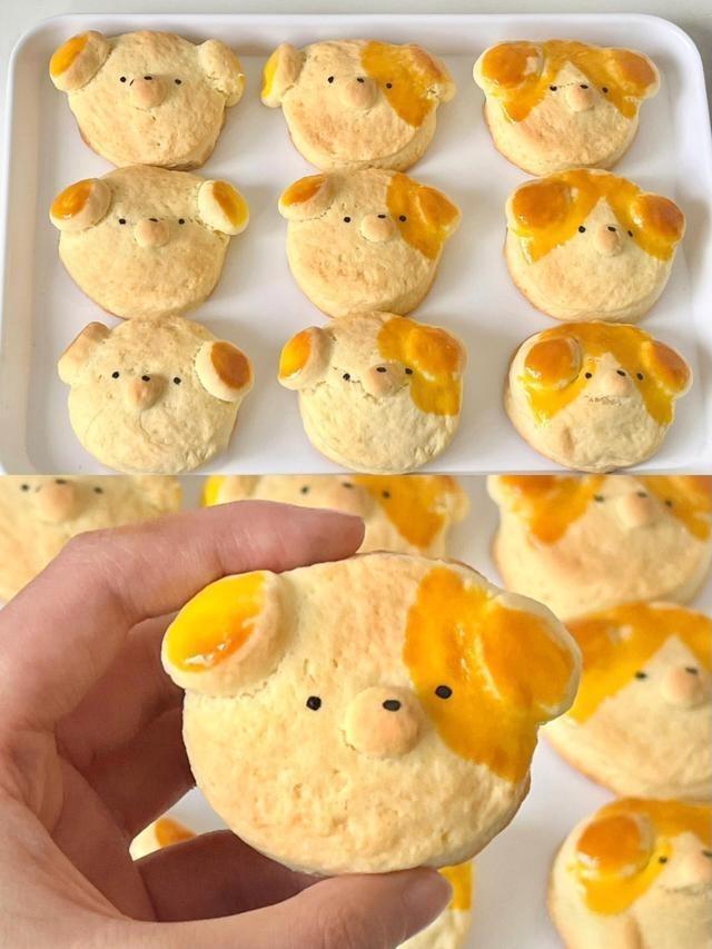 Pig-shaped pastries on a tray with a hand holding one
